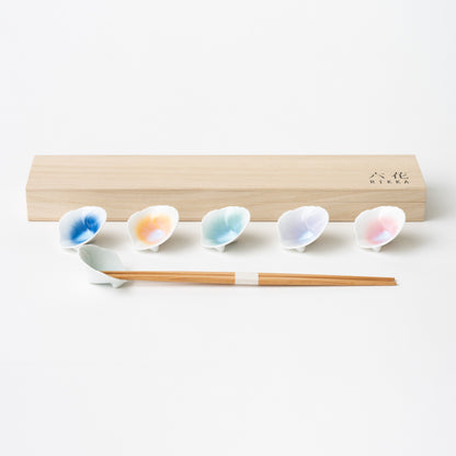 Ceramic chopstick rests in the shape of a flower. Colors in blue, orange, green, pink and lavender. Comes in a wooden box